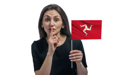 Happy young white woman holding flag of Isle of Man and holds a finger to her lips isolated on a white background.の写真素材