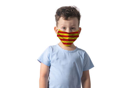 Respirator with flag of Catalonia. White boy puts on medical face mask isolated on white background.の写真素材