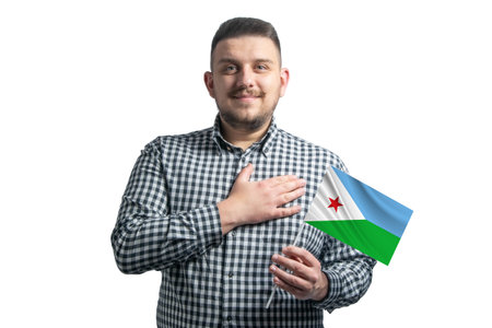 White guy holding a flag of Djibouti and holds his hand on his heart isolated on a white background With love to Djibouti.の写真素材