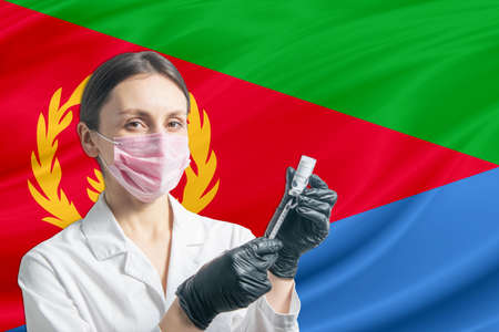 Girl doctor prepares vaccination against the background of the Eritrea flag. Vaccination concept Eritrea.の写真素材
