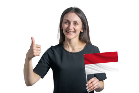 Happy young white woman holding flag of Indonesia and shows the class by hand isolated on a white background.の写真素材