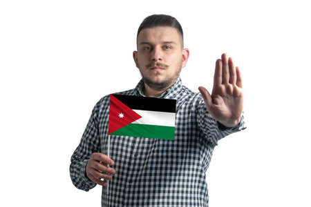 White guy holding a flag of Jordan and with a serious face shows a hand stop sign isolated on a white background.の写真素材