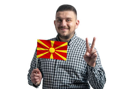 White guy holding a flag of Northern Macedonia and shows two fingers isolated on a white background.の写真素材