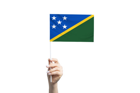 Beautiful female hand holding Solomon Islands flag, isolated on white background.の写真素材