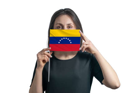 Happy young white woman holding flag Venezuela flag and covers her face with it isolated on a white background.の写真素材