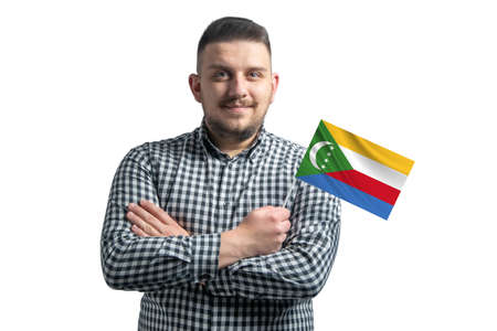 White guy holding a flag of Comoros smiling confident with crossed arms isolated on a white background.の写真素材