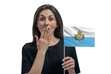 Happy young white woman holding flag of San Marino and covers her mouth with her hand isolated on a white background.の写真素材