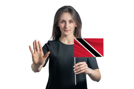Happy young white woman holding flag of Trinidad and Tobago and with a serious face shows a hand stop sign isolated on a white background.の写真素材