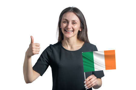 Happy young white woman holding flag of Ireland and shows the class by hand isolated on a white background.の写真素材