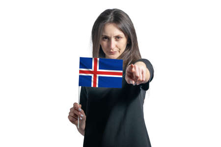 Happy young white woman holding flag of Iceland and points forward in front of him isolated on a white background.の写真素材