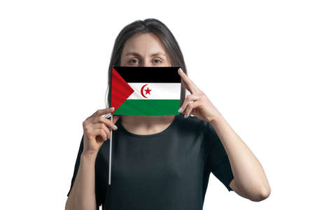 Happy young white woman holding flag Western Sahara flag and covers her face with it isolated on a white background.の写真素材