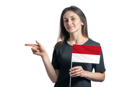Happy young white woman holding flag Indonesia and points to the left isolated on a white background.の写真素材