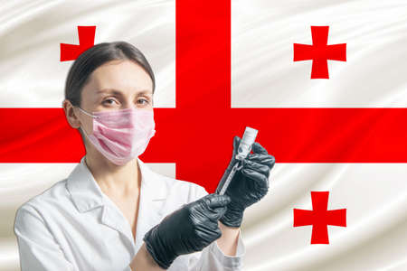 Girl doctor prepares vaccination against the background of the Georgia flag. Vaccination concept Georgia.の写真素材