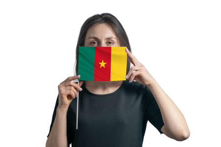 Happy young white woman holding flag Cameroon flag and covers her face with it isolated on a white background.の写真素材