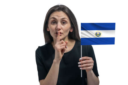 Happy young white woman holding flag of El Salvador and holds a finger to her lips isolated on a white background.の写真素材