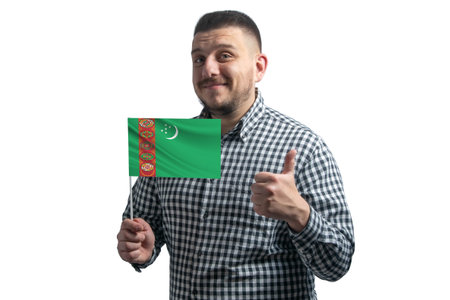 White guy holding a flag of Turkmenistan and shows the class by hand isolated on a white background. Like for Turkmenistan.の写真素材