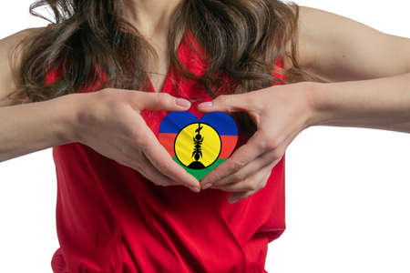 Love New Caledonia. The woman holds a heart in the form of the flag of New Caledonia on her chest. Concept of patriotism.の写真素材
