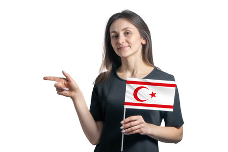 Happy young white woman holding flag Turkish Republic of Northern Cyprus and points to the left isolated on a white background.の写真素材