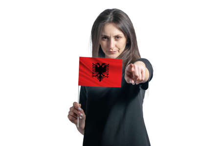 Happy young white woman holding flag of Albania and points forward in front of him isolated on a white background.の写真素材