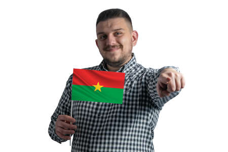 White guy holding a flag of Burkina Faso and points forward in front of him isolated on a white background.の写真素材