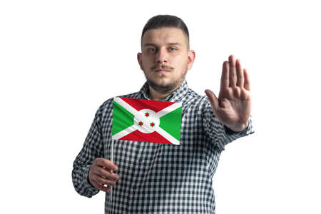 White guy holding a flag of Burundi and with a serious face shows a hand stop sign isolated on a white background.の写真素材
