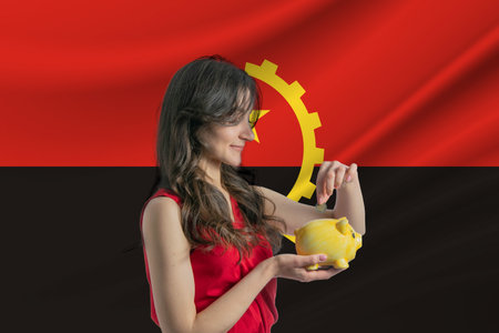 Economy in Angola. Accumulating and saving money in Angola. Woman putting money coin in piggy bank for saving money and plan financeの写真素材
