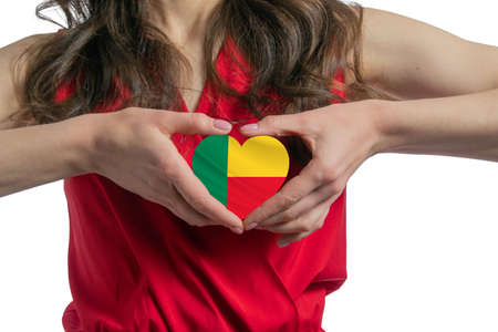 Love Benin. The woman holds a heart in the form of the flag of Benin on her chest. Concept of patriotism.の写真素材