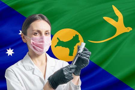 Girl doctor prepares vaccination against the background of the Christmas Island flag. Vaccination concept Christmas Island.の写真素材