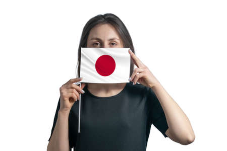 Happy young white woman holding flag Japan flag and covers her face with it isolated on a white background.の写真素材