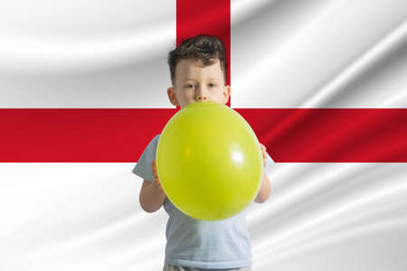 Children's day in England. White boy with a balloon on the background of the flag of England. Childrens day celebration conceptの写真素材