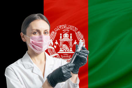 Girl doctor prepares vaccination against the background of the Afghanistan flag. Vaccination concept Afghanistan.の写真素材