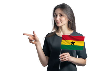 Happy young white woman holding flag Ghana and points to the left isolated on a white background.の写真素材