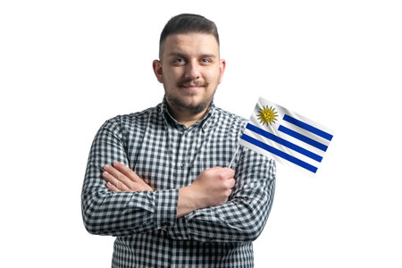 White guy holding a flag of Uruguay smiling confident with crossed arms isolated on a white background.の写真素材