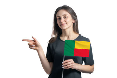 Happy young white woman holding flag Benin and points to the left isolated on a white background.の写真素材