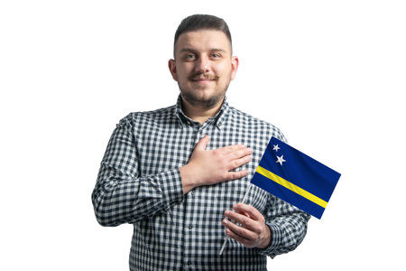 White guy holding a flag of Curacao and holds his hand on his heart isolated on a white background With love to Curacao.の写真素材