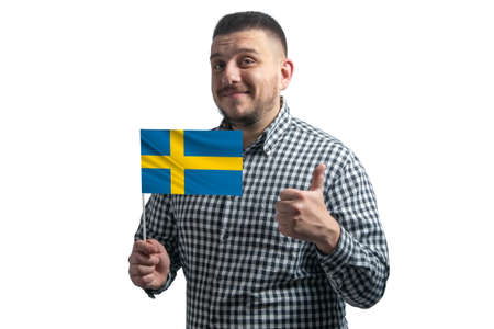 White guy holding a flag of Sweden and shows the class by hand isolated on a white background. Like for Sweden.の写真素材