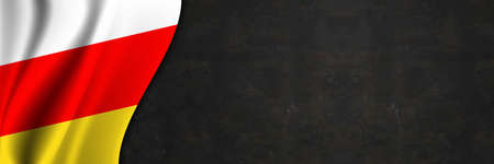 South Ossetia flag on concrete wall. Banner with fabric texture of the flag of South Ossetia.の写真素材