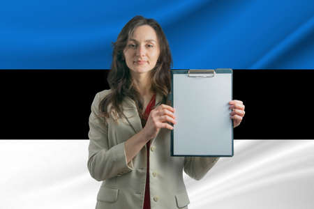 Study in Estonia Beautiful woman holding a sheet of paper in her hands. Girl on the background of the flag of Estonia.の写真素材