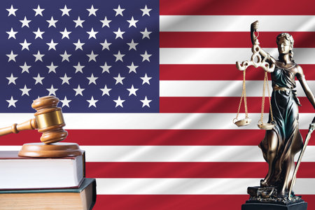 Law and justice in United States. Statue of themis and the gavel of the judge against the background of the flag of United States. Law and justice concept.の写真素材