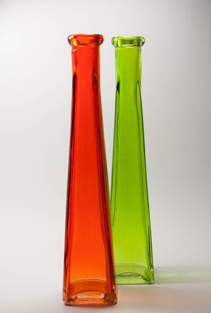 Colorful glass bottles in red and green isolated on white backgroundの写真素材