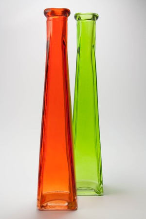 Colorful glass bottles in red and green isolated on white backgroundの写真素材