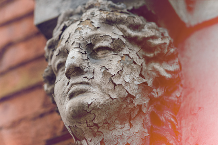 Old white Caryatid made of concrete in an old brick house. The sculpture cracks.の写真素材