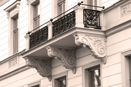 Balcony with cast iron railing in the Baroque style. The facade is light. The railing is painted black.の写真素材