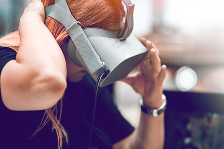 Girl with virtual Reality Glasses. Glasses are made of plastic. The background is blurred.の写真素材