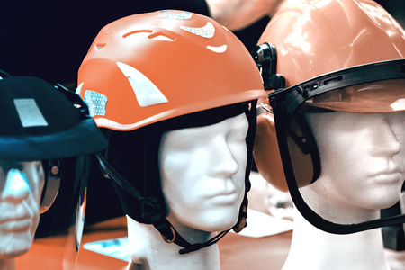 Protective plastic helmets on mannequins with protective glass. Small details are visible. The background is blurred.の写真素材