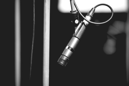 An empty stage with a dark microphone on the counter. The background is blurred. Shallow depth of field.の写真素材