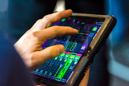 Touch tablet with stage speaker control panel. The tablet displays readings. The background is blurred.の写真素材