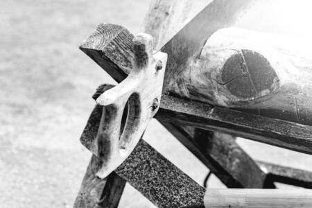 An old rusty saw with a wooden handle. Visible roughness and cracks. The background is blurred.の写真素材