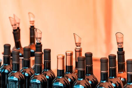 Many bottles of alcohol and stale drinks closed lids and stoppers. The background is blurred.の写真素材