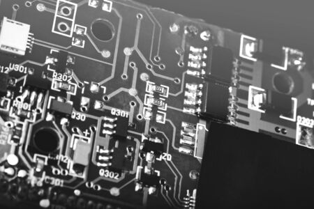 A close-up microchip with many electrical components placed on the Board. The background is blurred.の写真素材